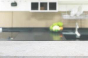 white marble stone counter top with blurred kitchen background photo