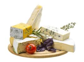 variedad de quesos sobre tabla de madera y fondo blanco foto
