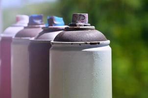 A few used aerosol paint sprayers lie on the windowsill in the workshop of a graffiti artist. The concept of street art and illegal drawing on the walls. Youth hobby photo