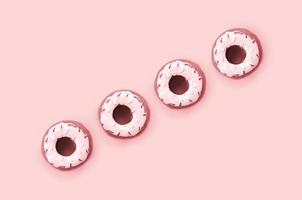 Many small plastic donuts lies on a pastel colorful background. Flat lay minimal pattern. Top view photo