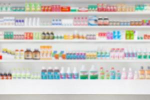 Empty wood counter top with pharmacy drugstore shelves blur pharmaceutical medicine product background photo