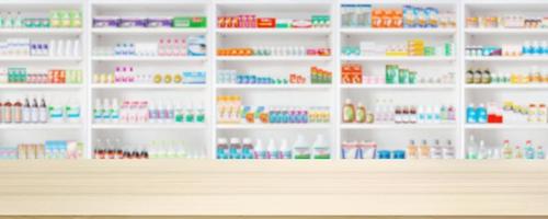 Empty wood counter top with pharmacy drugstore shelves blur pharmaceutical medicine product background photo