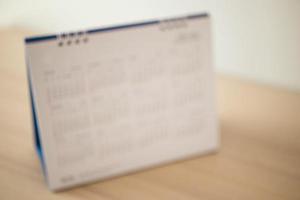 Blur calendar page close up on wood table background business planning appointment meeting concept photo