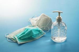 Alcohol sanitizer gel hand wash bottle with N95 Medical face mask on blue background covid-19 Coronavirus prevention concept photo