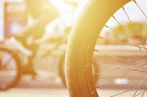 una rueda de bicicleta bmx con el telón de fondo de una calle borrosa con ciclistas. concepto de deportes extremos foto