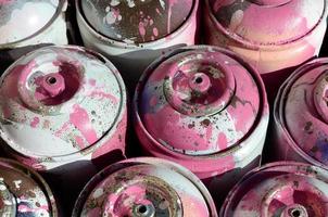 muchos tanques de metal rosa usados con pintura para dibujar graffiti foto