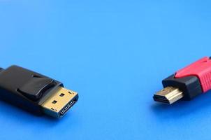 Audio video HDMI computer cable plug and 20-pin male DisplayPort gold plated connector for a flawless connection on a blue background photo