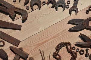 A set of old and rusty tools lies on a wooden table in the workshop photo