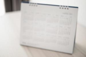 Blur calendar page close up on wood table background business planning appointment meeting concept photo