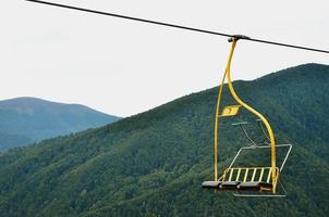 The seats of the cable car on the background of Mount Makovitsa, one of the Carpathian Mountains photo