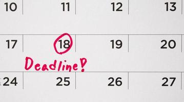 Deadline write on white calendar page date close up photo