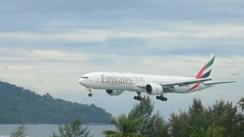 phuket, Thailand december 4, 2016 - boeing 777 emiraten a6 ebx naderen en landen Aan nat landingsbaan van phuket luchthaven. video