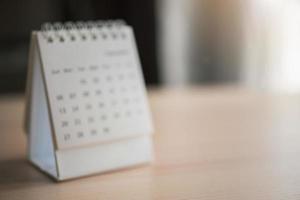 Blur calendar page close up on wood table background business planning appointment meeting concept photo