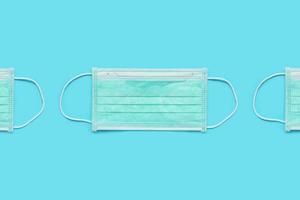 Surgical face mask on blue background protection against COVID-19 coronavirus. Healthcare and medical concept photo