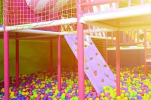 muchas bolas de plástico de colores en una piscina para niños en un patio de recreo foto