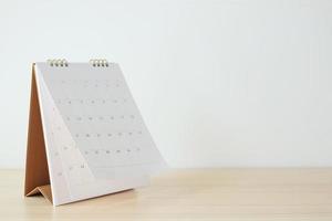 Calendar page flipping sheet on wood table background business schedule planning appointment meeting concept photo