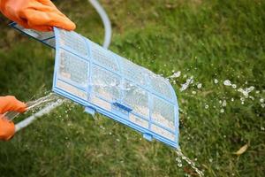 Asian man cleaning air conditioner dirty filter photo