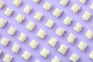 Colorful marshmallow laid out on violet paper background. pastel creative textured pattern. minimal photo