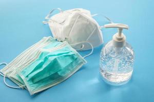 Alcohol sanitizer gel hand wash bottle with N95 Medical face mask on blue background covid-19 Coronavirus prevention concept photo