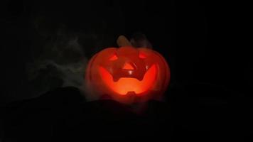 citrouille d'halloween qui a de la lumière et de la fumée dans sa bouche avec un fond sombre. video