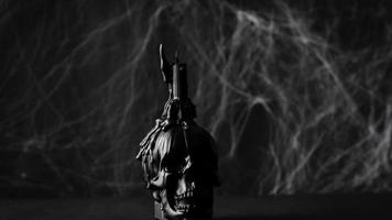 zwart kaars Aan schedel in beweging naar spinneweb achtergrond en licht omhoog de vlam. hou op beweging halloween. video