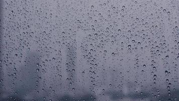 Footage of rain drop on glass window with blurred city background. video