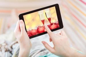 woman touches tablet-pc with red Xmas still life photo