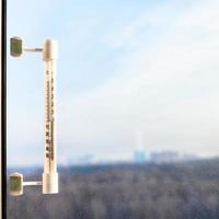 termómetro en el cristal de la ventana en el frío día de invierno