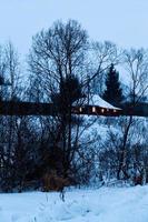 casa en el pueblo en la noche azul de invierno foto