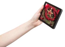 hand holds tablet pc with red star and tinsel photo
