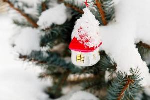 decoraciones del árbol de navidad en el árbol bajo la nieve al aire libre foto