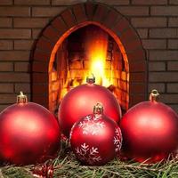 red Xmas baubles on spruce tree with fireplace photo