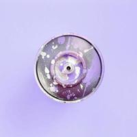 Single used spray can for graffiti drawing lies on a pastel colored backgroung. Street art painting concept. Minimal flat lay. Top view photo