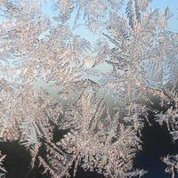 Snowflakes frost rime macro on window glass pane photo