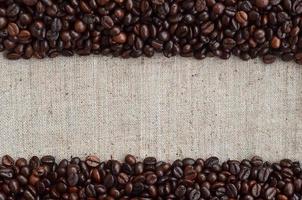 Texture of a gray canvas made of old and coarse burlap with coffee beans on it photo