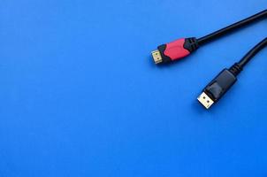 Audio video HDMI computer cable plug and 20-pin male DisplayPort gold plated connector for a flawless connection on a blue background photo