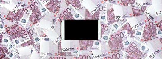 billetes morados de 500 euros y un smartphone con pantalla negra. copie el espacio el concepto de banca en línea, administración de dinero y compras con tecnología moderna foto