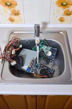 Hardware in kitchen sink under the water flow computer cleaning metaphoric concept photo