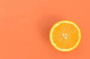 Top view of a one orange fruit slice on bright background in orange color. A saturated citrus texture image photo