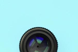 Camera lens with a closed aperture lie on texture background of fashion pastel blue color paper photo