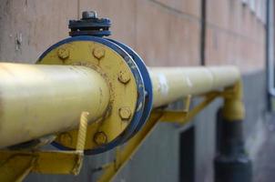 Yellow gas pipe in front of residential building wall photo