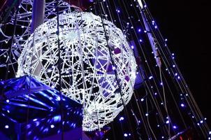 Fragment of the New Year tree. A lot of round lights of blue color are located on a conical frame photo