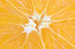 Top view of a fragment of the orange fruit slice close up. Macro background texture photo