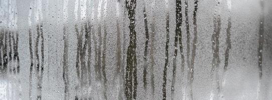 The texture of a misted glass with a lot of drops and condensation flows. Background image photo