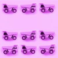 Many small purple toy trucks on texture background of fashion pastel purple color paper photo