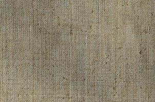 Texture of a gray canvas made of old and coarse burlap. Top view photo