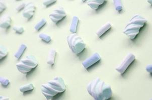 Colorful marshmallow laid out on lime paper background. pastel creative textured pattern photo