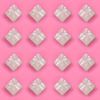 A lot of pink gift boxes lies on texture background of fashion pastel pink color paper in minimal concept. Abstract trendy pattern photo