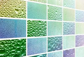 A collage of many different fragments of glass, decorated with rain drops from the condensate. Spring tones with green and blue colors photo
