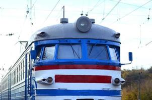 Old soviet electric train with outdated design moving by rail photo